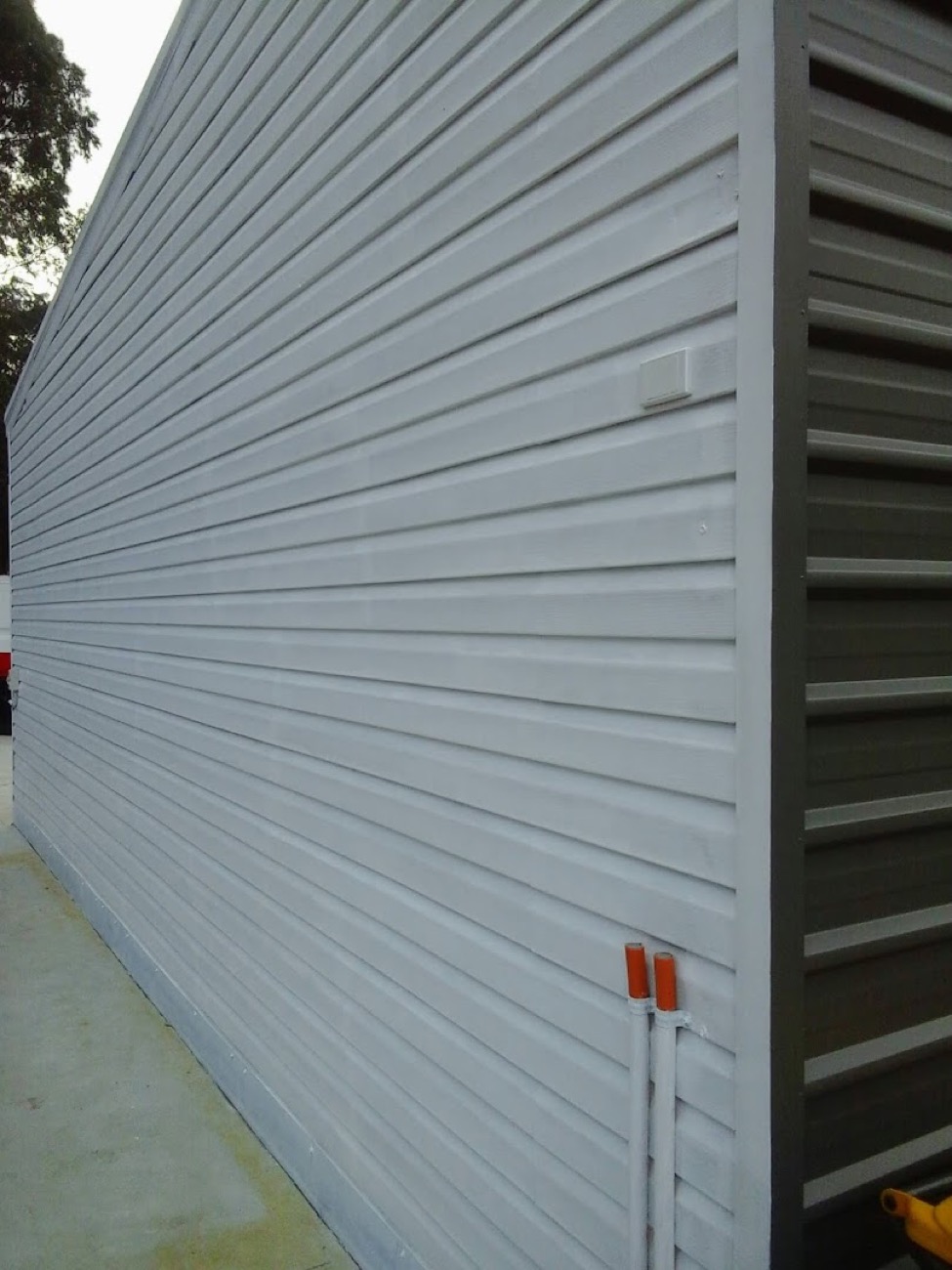 A white roller shutter closed over an opening in an exterior wall