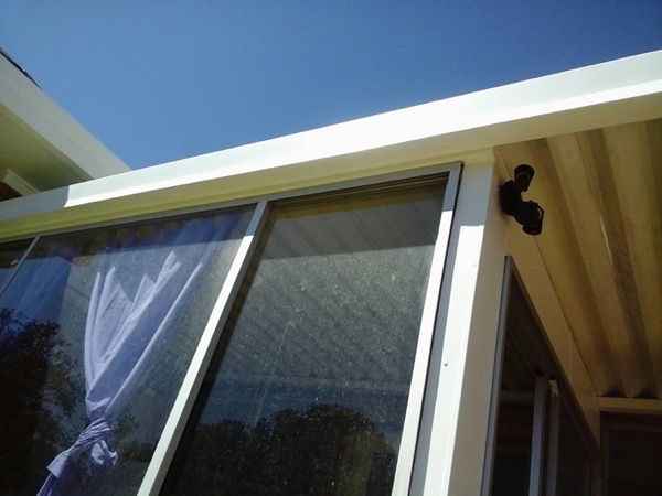 A window and awning fitted to a brick wall under a clear sky
