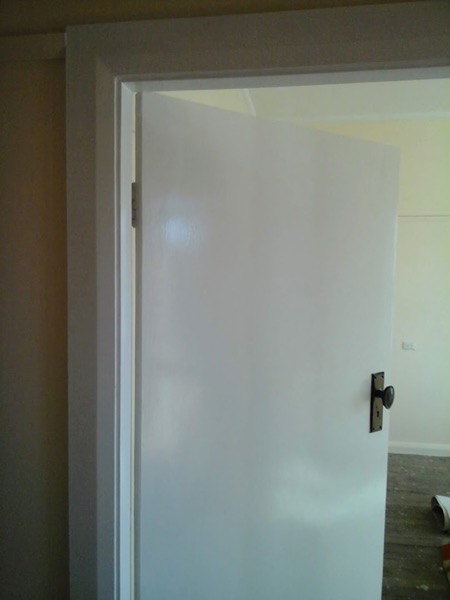 A plain white door closed in a finished doorway