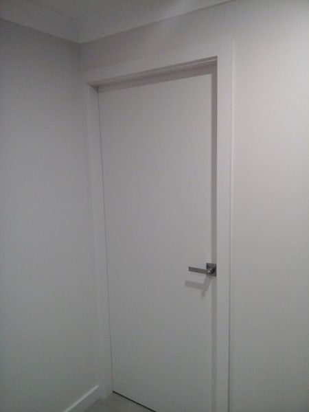 A white door closed at the end of a freshly painted hallway