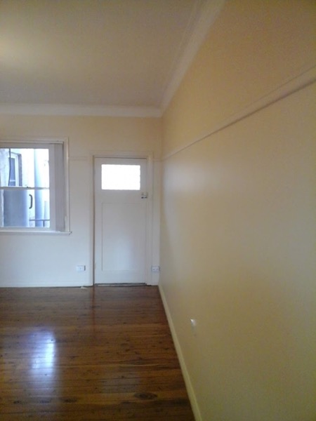 A freshly painted interior room with sunlight across the floor