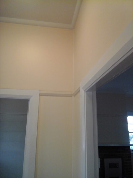 A repainted room with a doorway through to the next room