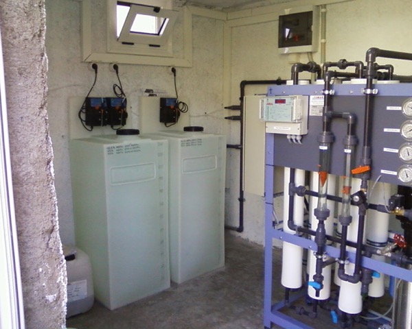 A water treatment room with filter housings and control cabinets