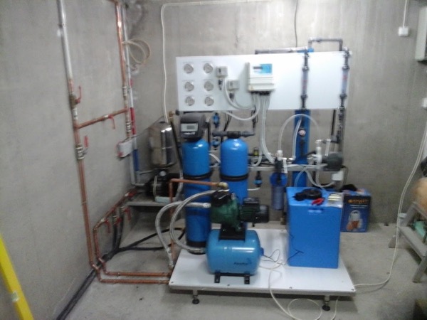 A pump and filtration set mounted against a brick wall