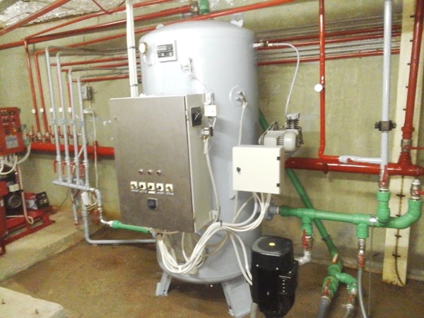 A plumbing manifold with coloured pipework and a control box